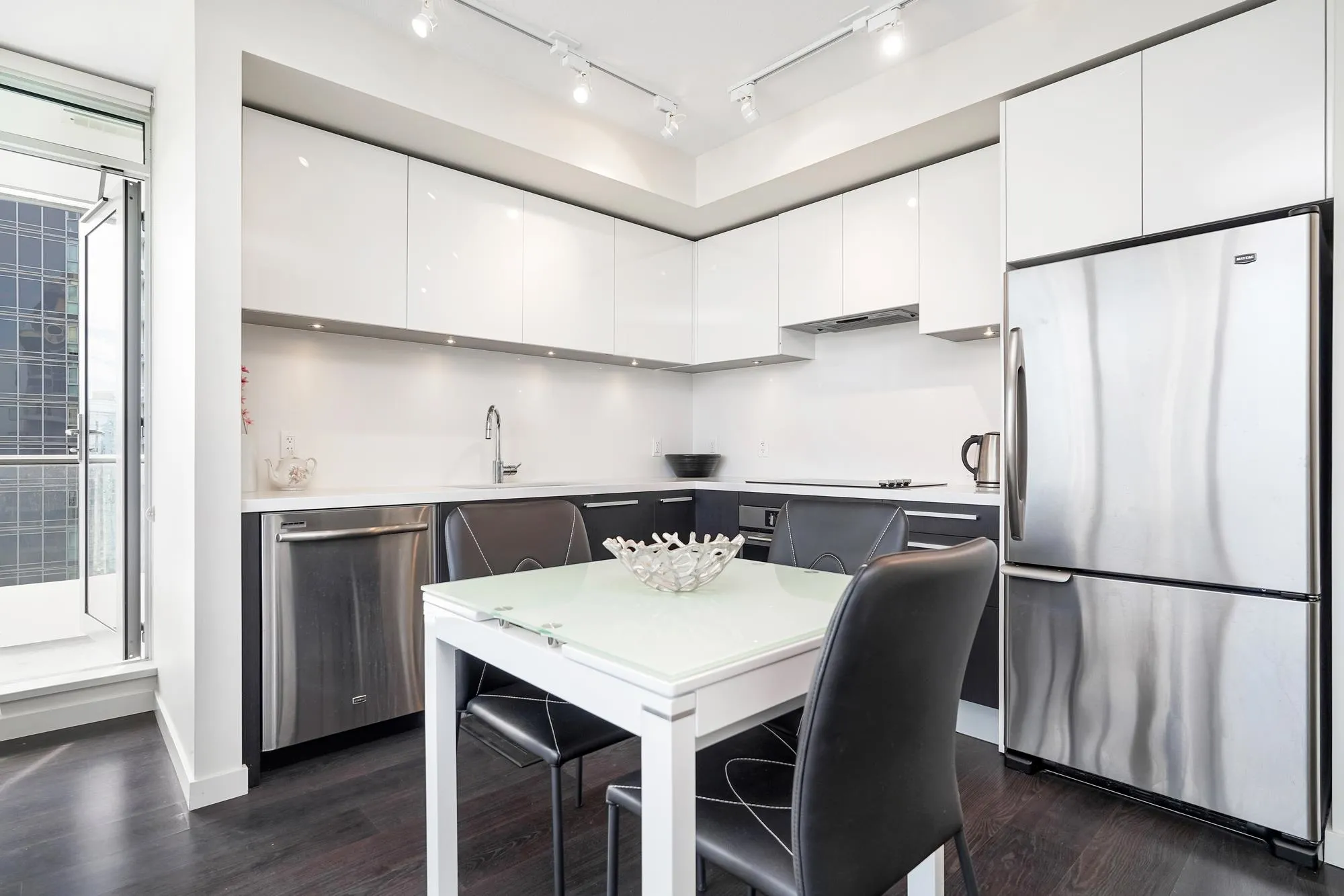 Modern and sleek kitchen with lots of storage and stainless steel appliances.