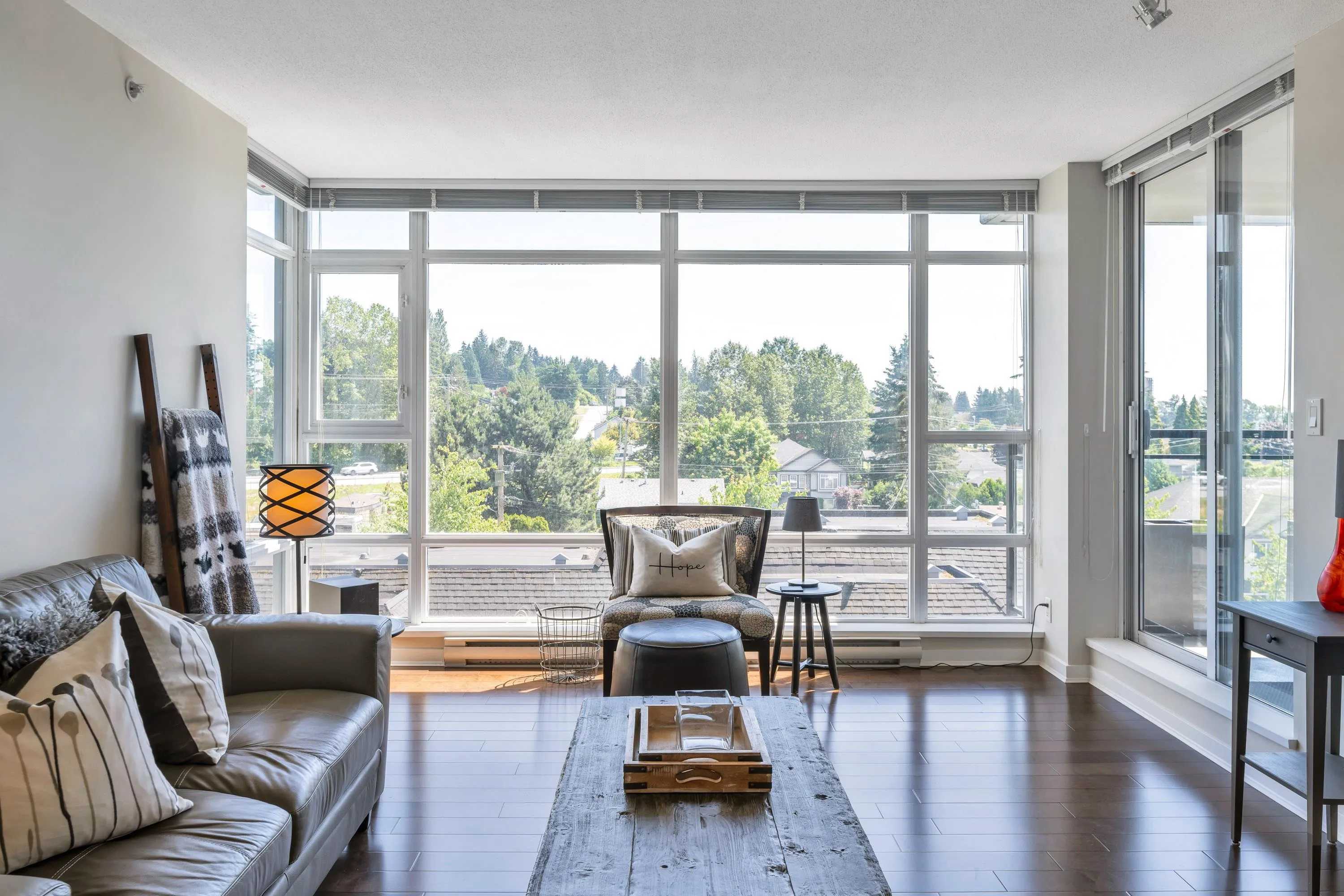 Floor to ceiling windows allow natural light to flow into the living room.