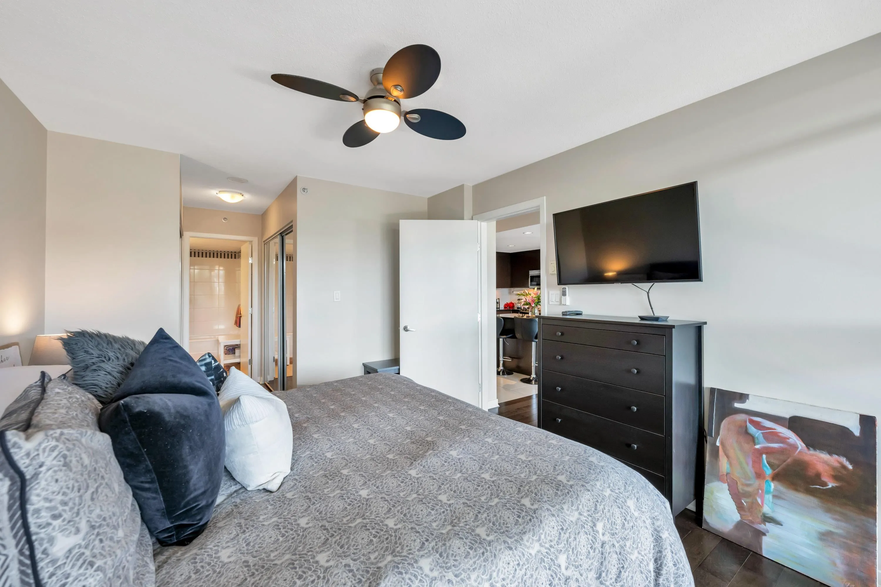 The primary bedroom features hardwood flooring, an ensuite bathroom, walk-through closet, and an abundance of natural light.