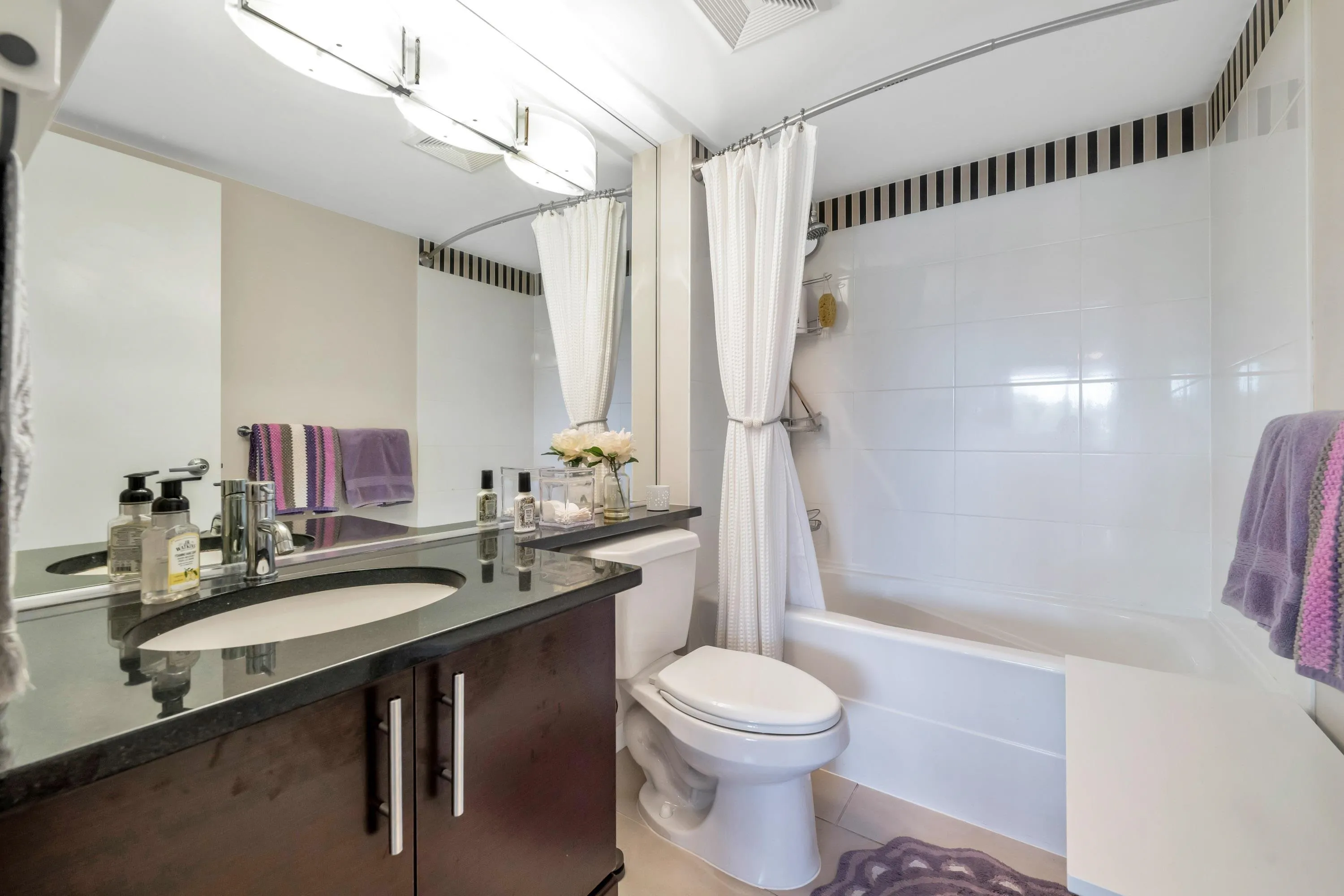 The ensuite bath is equipped with a modern vanity, tile floor and full sized tub/shower.